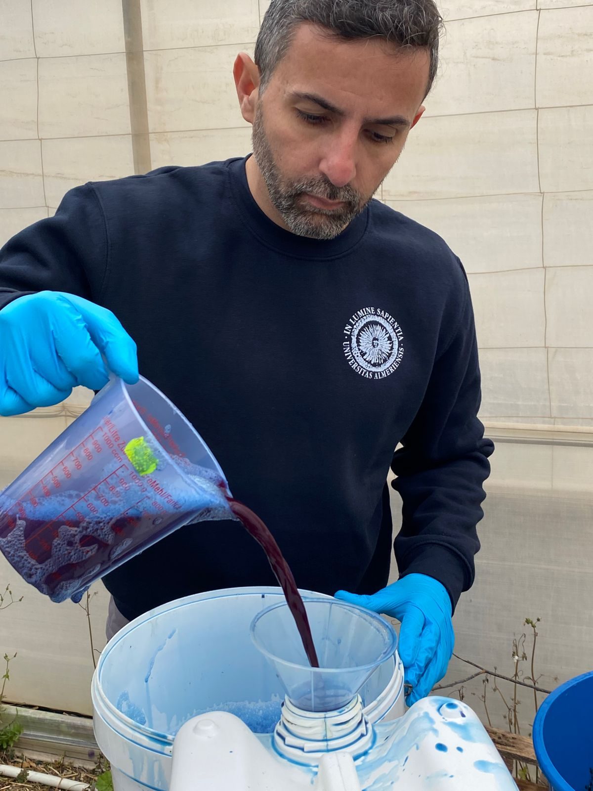 A founder pouring extract through a funnel at the pilot plant